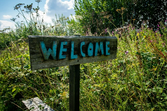 Wooden sign with welcome painted in blue letters